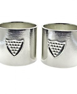 Pair of Cornish tin napkin rings with shield motif.