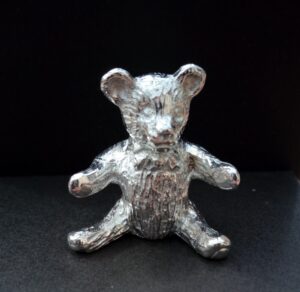 Sitting teddy cast in Cornish tin